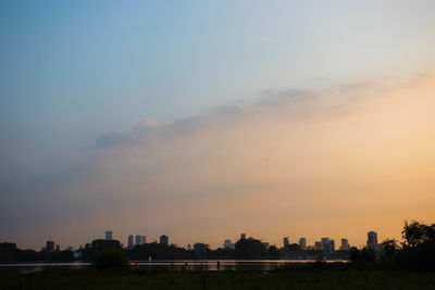 Silhouette buildings against sky at sunset