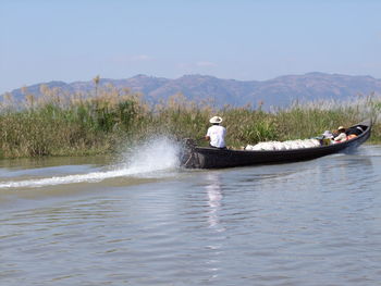 Man on boat in sea against sky