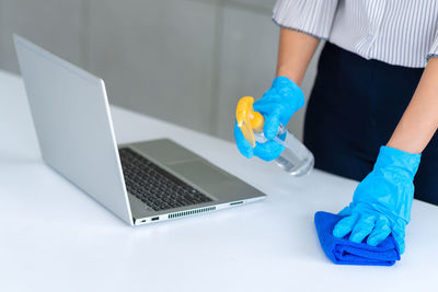 Midsection of man using laptop on table