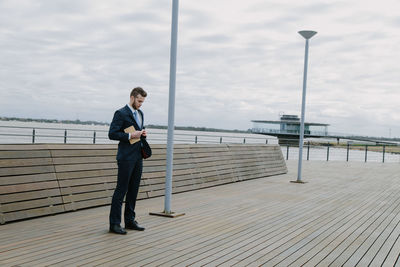 Full length of man standing on pier against sky