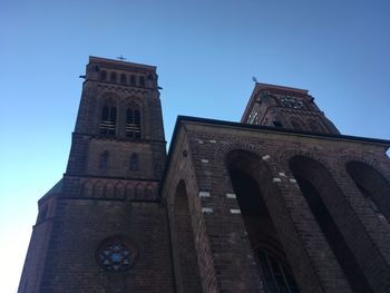 Low angle view of historic building against clear blue sky