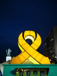 Low angle view of illuminated building against blue sky