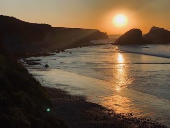 Scenic view of beach against sky during sunset