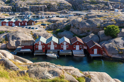 Houses by river and buildings against rock formation