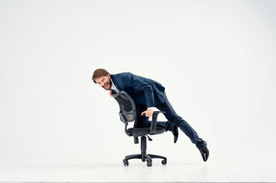 Young man on chair against white background