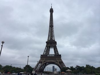 Low angle view of eiffel tower against cloudy sky