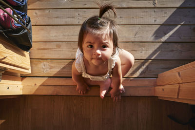 Baby girl sitting on wooden deck