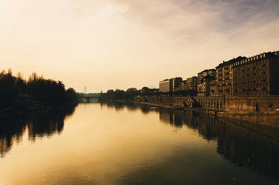 Scenic view of river against sky at sunset