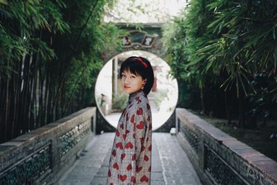 Portrait of a girl standing against trees