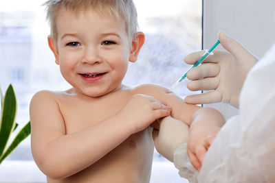 Child vaccination. doctor vaccinating little smiling boy. vaccination. vaccine covid 19, flu