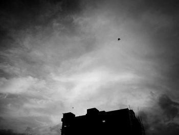 Low angle view of silhouette birds flying against sky