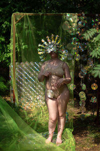 Portrait a woman in a reflective mask in a beige bikini against the background of a cd / dvd case