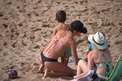 Rear view of friends enjoying at beach