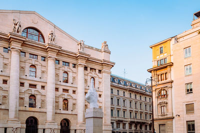 Wide angle view of piazza degli affari in milan with famous artwork in the center