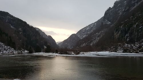 Scenic view of lake by mountains against sky