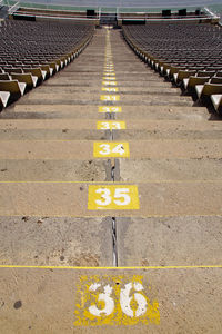 High angle view of yellow text on footpath steps in stadium