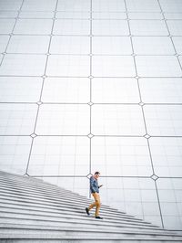 Full length of man standing against white wall