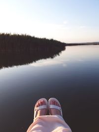 Low section of man on lake against sky