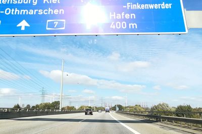 Information sign on road against sky