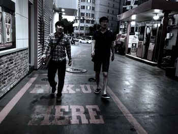 Full length of young men walking on street at night