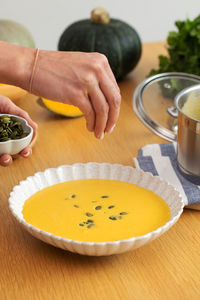 Cropped hand of woman holding food on table