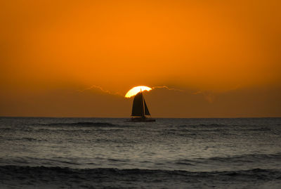 Silhouette boat in sea against orange sky during sunset