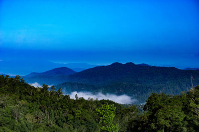 Scenic view of mountains against blue sky