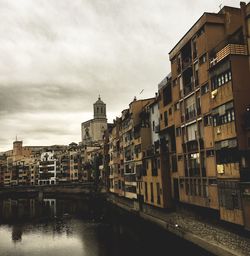 Buildings in city against cloudy sky