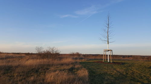 Electricity pylon on field against sky