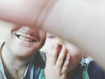 Close-up of cheerful father and son enjoying at home