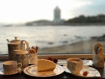 Close-up of breakfast on table against sea