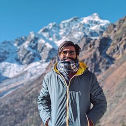 Portrait of man standing on snowcapped mountain