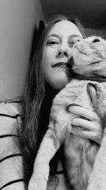 Portrait of beautiful woman with cat at home