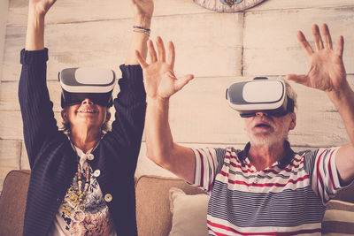 Senior couple using virtual reality headset at home