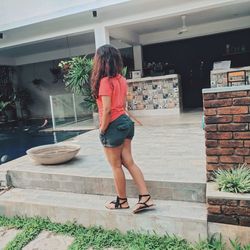 Rear view of woman standing by potted plants