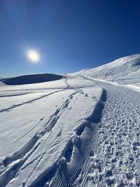 Snow covered landscape against sky