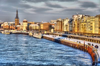 View of bridge over river by buildings in city