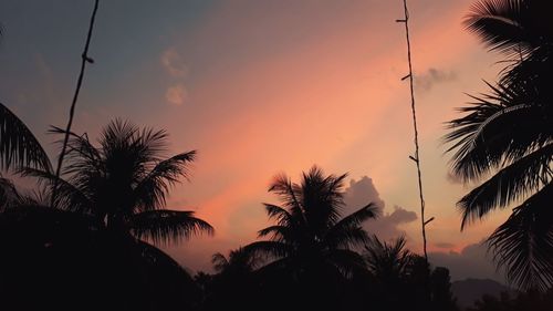 Low angle view of silhouette palm trees against romantic sky