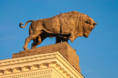 Low angle view of statue against blue sky