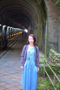 Portrait of woman standing against tunnel