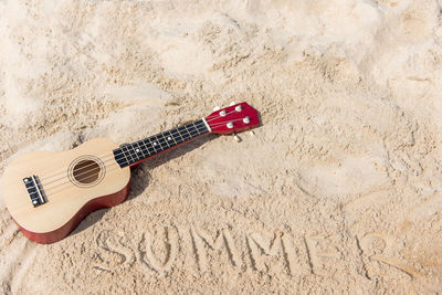 High angle view of guitar on sand