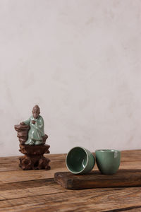 Man sitting on table against wall at home