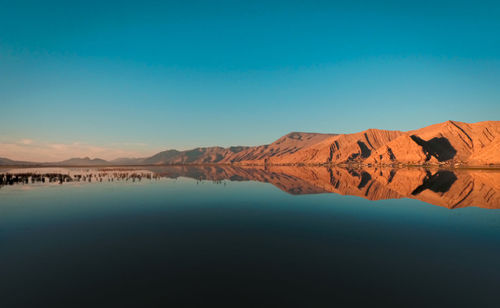 Scenic view of lake against clear blue sky