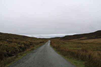 Road passing through landscape against sky