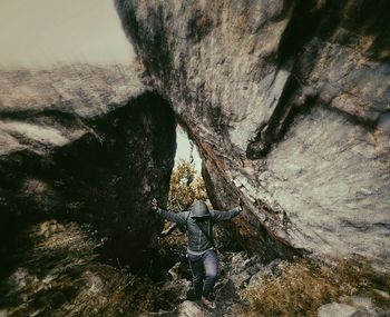 Man standing by rock statue in water