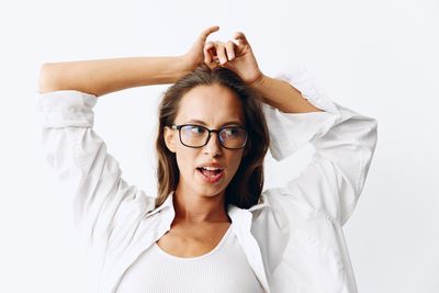 Young woman with arms crossed against white background