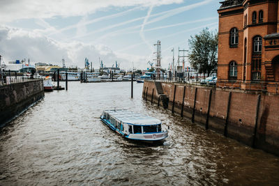 Nautical vessel on canal amidst buildings in city