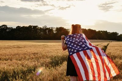 Rear view of woman holding american flag