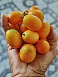 Close-up of hand holding orange
