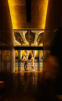 Rear view of people walking in corridor